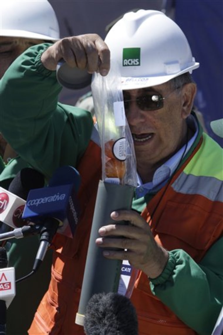 Alejandro Pino, of the Chilean Security Association, ACHS, puts some foods into a tube to be sent to trapped miners while showing the operation to the press outside the San Jose mine in Copiapo, Chile, Friday, Sept. 24. Thirty-three miners have been trapped deep underground in the copper and gold mine since it collapsed on Aug. 5.